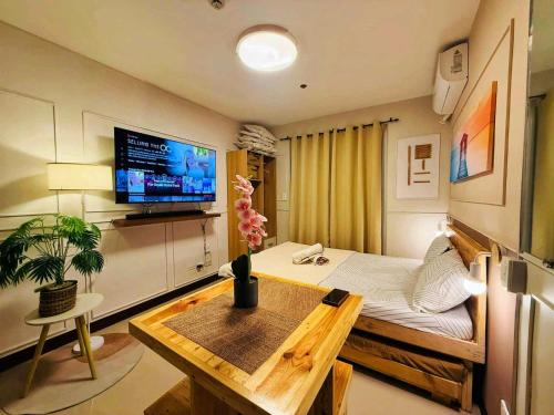 a room with a bed and a table and a tv at Zayd's Place in Basbas