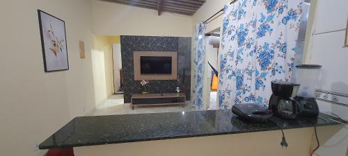 une cuisine avec un comptoir et une télévision dans une pièce dans l'établissement Cantinho do sossego, à Cabo Frio