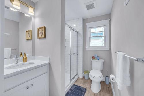 a white bathroom with a toilet and a sink at Private Beach Home in Mantoloking in Mantoloking