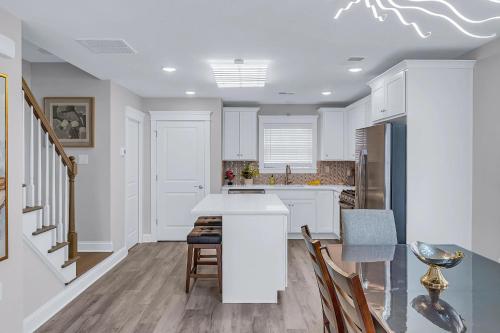 a kitchen with white cabinets and a table and chairs at Private Beach Home in Mantoloking in Mantoloking