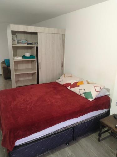 a bedroom with a bed with a red blanket on it at APTO EN NORTE DE ARMENIA in Armenia