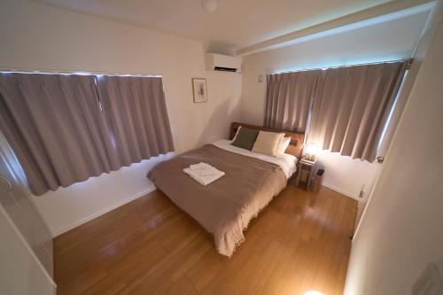 a small bedroom with a bed and a window at Koeda House in Tokyo