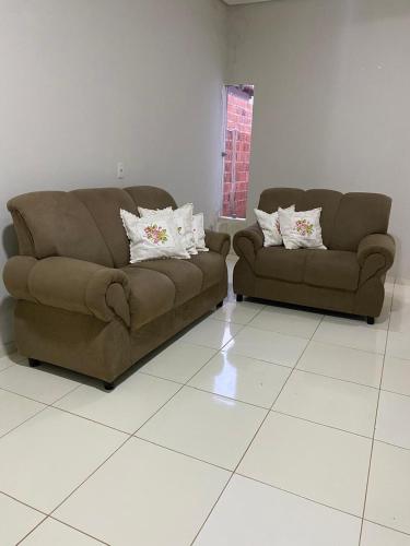two brown couches sitting in a living room at Casa de temporada in São Raimundo Nonato