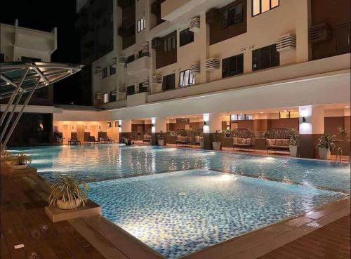 a large swimming pool in the middle of a hotel at Cozy 1 bedroom at BE Residences Condominium with balcony near IT Park in Tabok