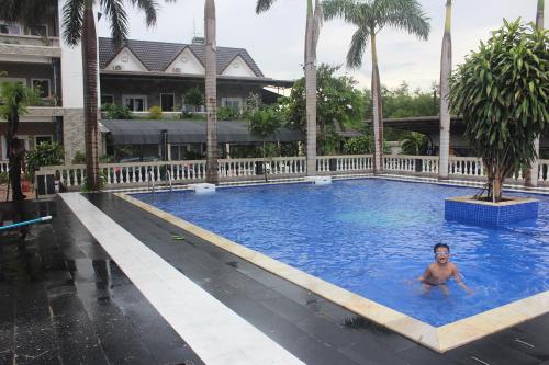 a man in a swimming pool at a hotel at Hoang Thanh Thuy 3 Hotel in Ho Coc