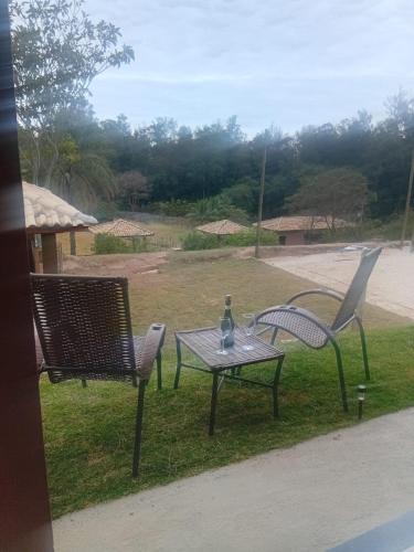 two chairs and a table with a wine glass on it at Vinhedos da Serra com Ar quente e frio até 5 pessoas in Espirito Santo Do Pinhal