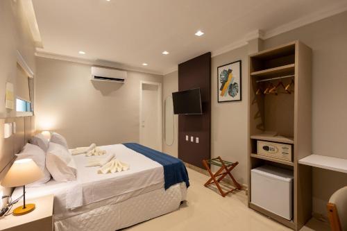 a bedroom with a bed and a television in it at Aira Hotel in Sobral