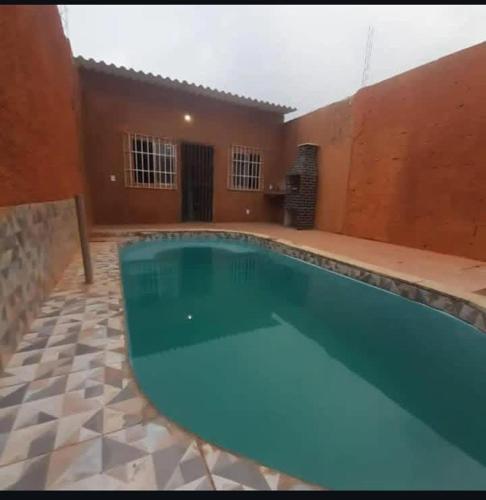 a large swimming pool in a courtyard with a house at Hospedaria Km 20 da Br 040 Luziânia in Luziânia