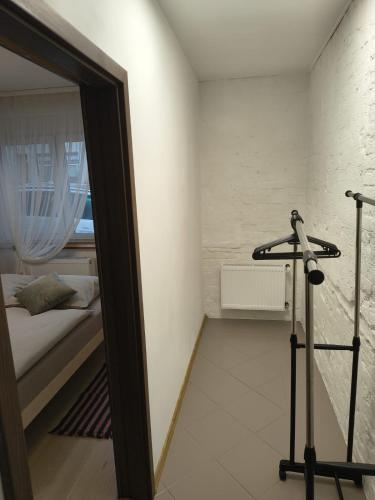 a room with a bed and a mirror and a treadmill at Apartamenty Stara Cegła in Zgorzelec