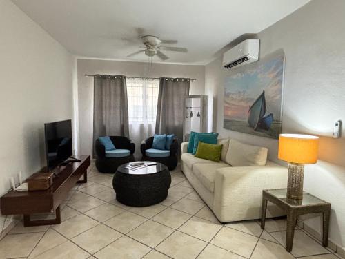 a living room with a couch and a tv at Acogedor apartamento minimalista Mai in Puerto Vallarta