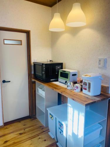 a kitchen counter with a microwave and a toaster oven at Auberge Tsukiyama in Yamatotakada