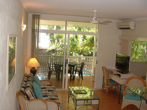 a living room with a couch and a table at Palm Cove Tropic Apartments in Palm Cove