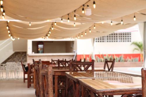 a restaurant with wooden tables and chairs under a tent at Hotel Pikeiro Blue in Manta