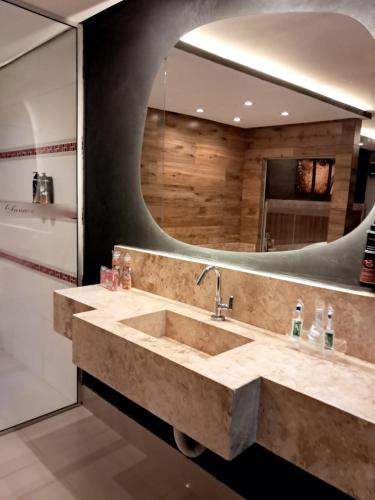 a bathroom with a sink and a large mirror at Motel Lunary in Piedade
