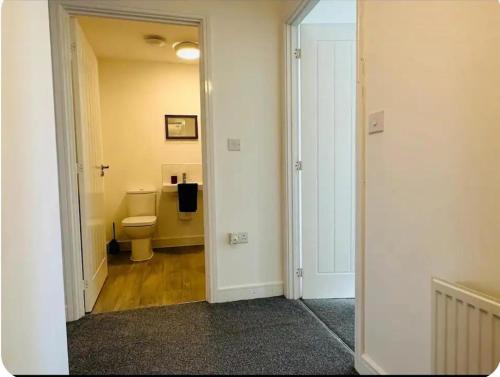 a bathroom with a toilet and a hallway at Maize Walk Retreat - Ashford Beauty in Ashford