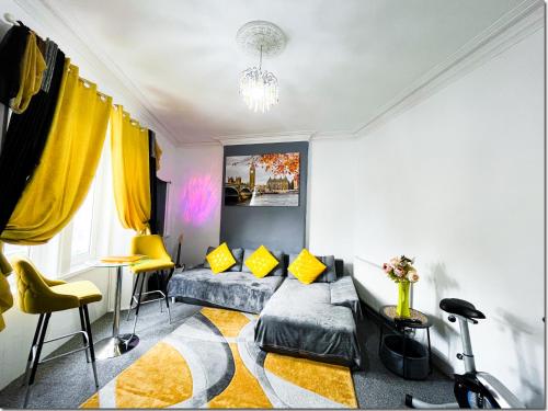 a living room with a couch and yellow chairs at Spacious 3 Bedroom Entire Apartment Self Check in in Fife