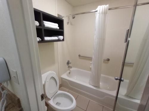 a bathroom with a toilet and a tub and a shower at Best Western Garden Inn in San Antonio