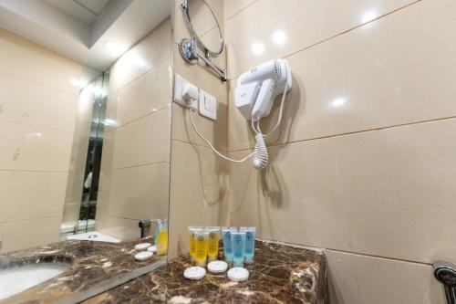 Baño con teléfono en la pared junto a un lavabo en Hayah Plaza Hotel, en Medina