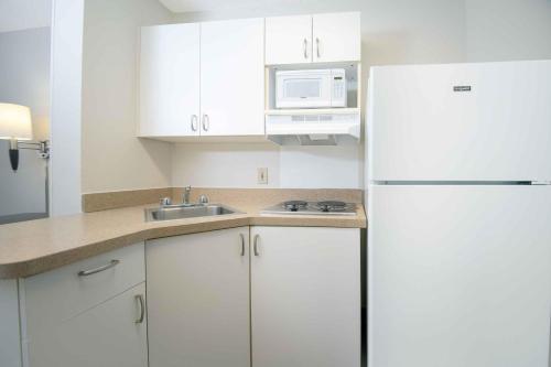 a kitchen with white cabinets and a white refrigerator at Extended Stay America Suites - Hartford - Farmington in Farmington