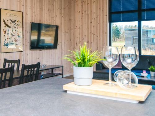a table with two wine glasses and a potted plant at 5 star holiday home in Grenaa in Brøndstrup