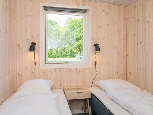 two beds in a room with a window at 5 star holiday home in Grenaa in Brøndstrup