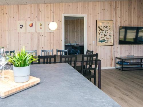 a dining room with a table and chairs and wooden walls at 5 star holiday home in Grenaa in Brøndstrup