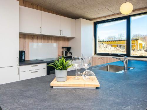 a kitchen with wine glasses and a potted plant on a counter at 5 star holiday home in Grenaa in Brøndstrup