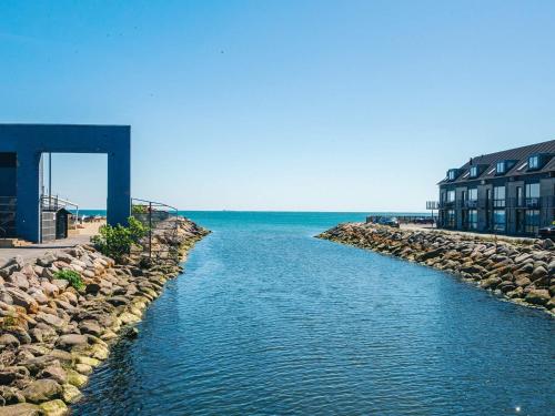 a body of water next to a building and the ocean at 5 star holiday home in Grenaa in Brøndstrup