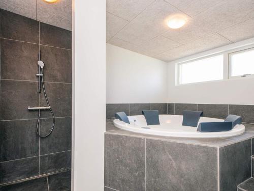 a bathroom with a bath tub with blue chairs at 5 star holiday home in Grenaa in Brøndstrup