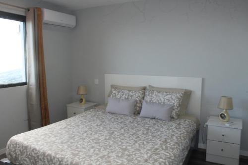 Un dormitorio con una cama con dos mesitas de noche y dos lámparas. en Nature Apartment 1 with Pool, en Arco da Calheta