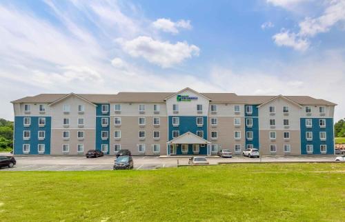 a large building with cars parked in a parking lot at Extended Stay America Select Suites - Fayetteville in Fayetteville