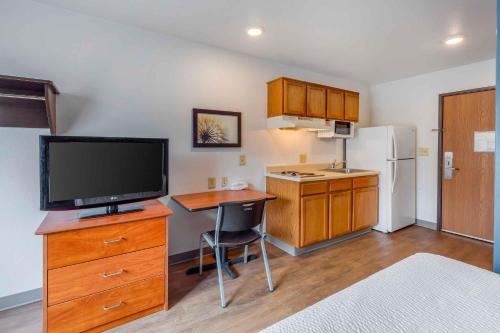 a kitchen with a television and a desk with a table at Extended Stay America Select Suites - Fayetteville in Fayetteville