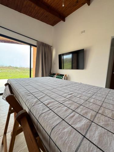 a bedroom with a large bed and a flat screen tv at Cabaña YMBYATY in Colonia Carlos Pellegrini