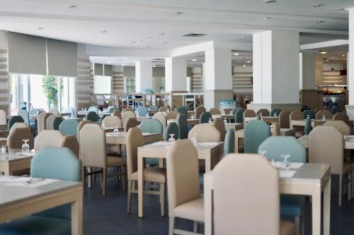 an empty dining room with tables and chairs at Hotel El Mansour Mahdia Thalasso & Spa in Mahdia