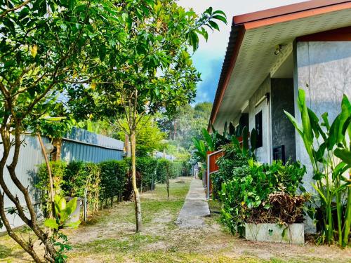 une maison avec des arbres et un trottoir à côté dans l'établissement Longhaad Lanta garden resort, à Ban Ai Dao