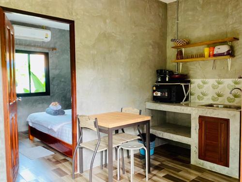 - une cuisine avec une table et un lit dans une chambre dans l'établissement Longhaad Lanta garden resort, à Ban Ai Dao