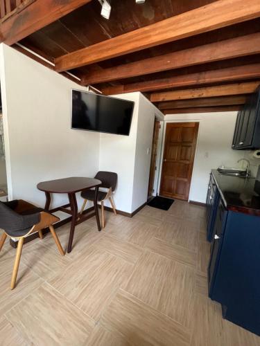a kitchen with a table and a tv on the wall at Phimai Pond House in Pi Mai