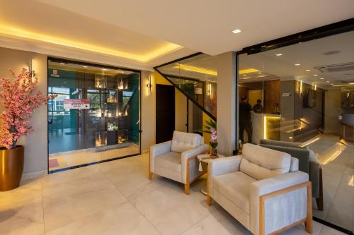 a lobby with two chairs and a table at Aira Hotel in Sobral