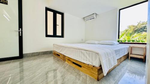 a bedroom with a bed and a large window at Queen House in Hoàng Ngà