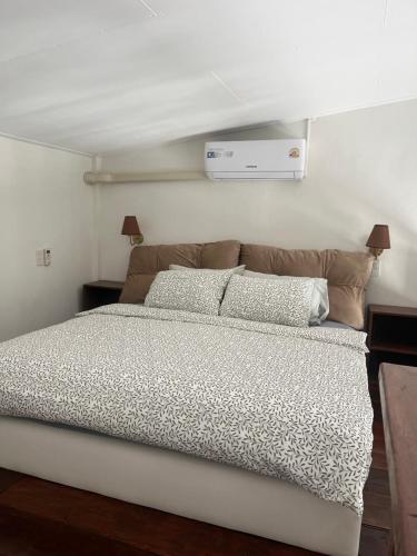 a bedroom with a large bed with two pillows at Phimai Pond House in Phimai