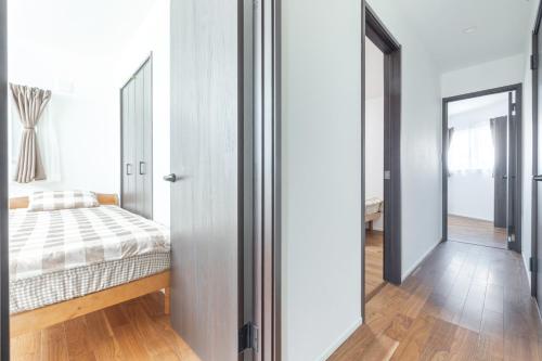 a bedroom with a bed and a mirror at 湘南楽軒 in Fujisawa