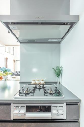 a kitchen with a stove top oven in a room at 湘南楽軒 in Fujisawa