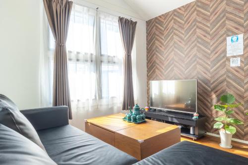 a living room with a couch and a television at 湘南楽軒 in Fujisawa