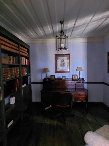 a room with a desk and a chair and a lamp at Casa do Brigadeiro - Miuzela