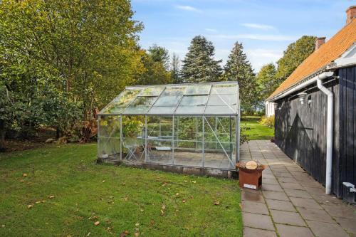 a greenhouse in a yard next to a building at 580 M2 Countryside Idyll With Activity Room in Haderslev