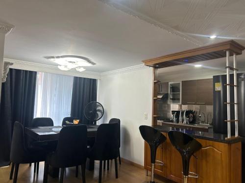 a dining room with a table and black chairs at Luxurious Stay 2 in Bello