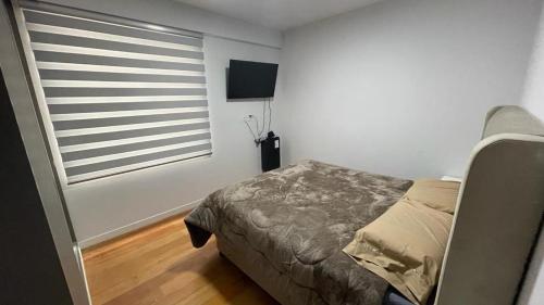 En eller flere senge i et værelse på Condominio Claure
