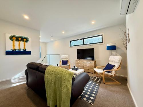 a living room with a couch and a tv at Aalto Retreat 3 - Chic Modern Close to Everything in Rosebud