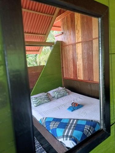 a bed in a tree house with a mirror at Lodge El Amargal - Reserva Natural, Ecoturismo & Surf in Nuquí