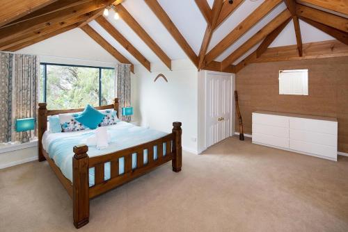 a bedroom with a wooden bed in a room at Tresco, Town central-beach end in Dunsborough